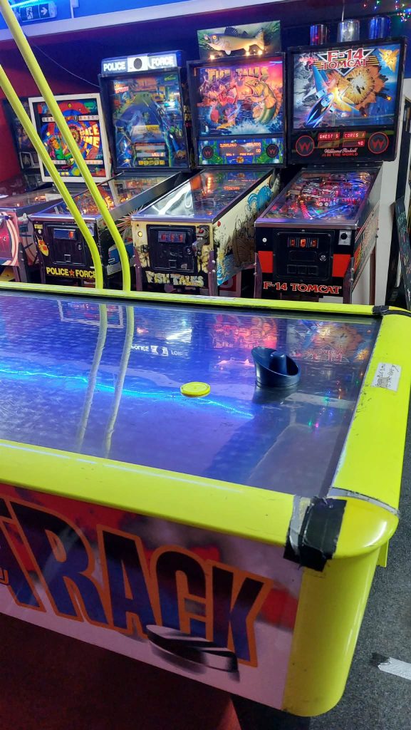 Air hockey table with Police Force, Fish Tales and F-14 Tomcat pinball machines behind