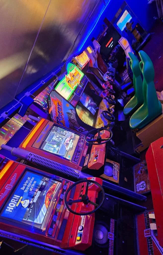 Row of sit-down racing cabinets with green seats
